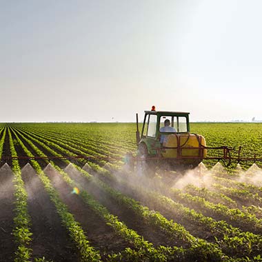 En landbrugstraktor befrugter afgrøder, der indfører nitrogen i form af ammoniak.